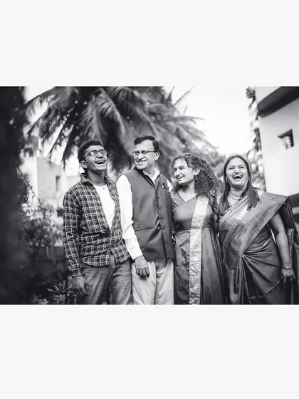 A candid black and white photo of a family sharing a big laugh together outdoors. These are the moments we strive to capture.