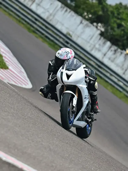 A rider on a Triumph Daytona 675 navigating an incline on the track.