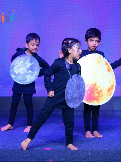 The Earth, Moon, and Sun perform on stage. Our productions are a collaborative effort, with each child playing an important part.