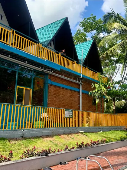 The beautiful A-frame architecture of our Nandi Hills resort, set against a backdrop of lush greenery and clear skies. It's a view that promises a rejuvenating stay.