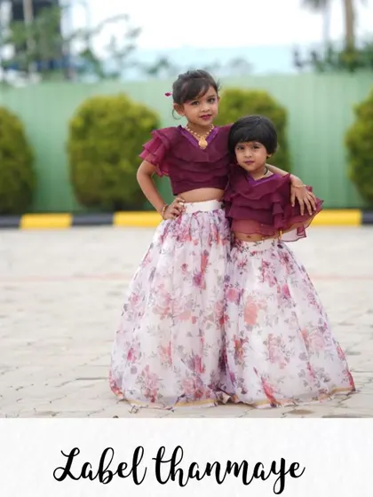 Sisters twinning in custom lehengas. I made these outfits with a floral organza skirt and a ruffled wine-colored crop top.