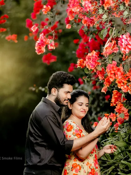 A close-up, romantic shot amidst blooming bougainvillea, highlighting the couple's intimacy and the natural beauty of the location.
