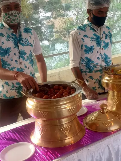This image captures my staff serving Gulab Jamuns at an outdoor event, showcasing the professional setup even for individual dessert stations.