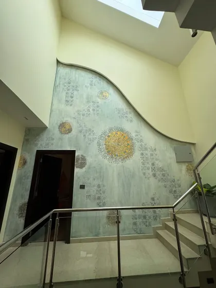 This was a surprise project where the client approved the design on the spot for this massive double-height wall. I created a textured, abstract mural with stenciled patterns and gold foil circles.