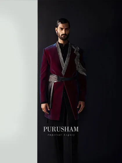 Designs that transpire the test of time. This wine-colored velvet jacket, with its asymmetrical silver embroidery and leather belt, welcomes you into a world of modern royalty.