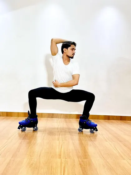 A powerful pose on roller skates, demonstrating the core strength and balance required for artistic skating.