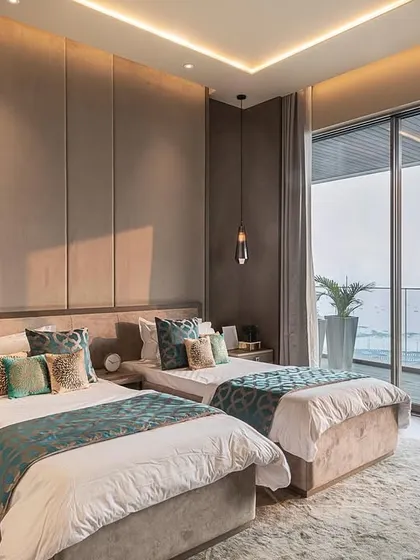 This bedroom in a Bandra residence masterfully combines luxury with comfort, overlooking the water. We created a striking contrast between deep blue furnishings and warm, textured wall panels. Bespoke pendant lights and curated decor add a refined character to the aesthetic.