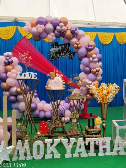 A closer look at the details of the outdoor birthday party, including the "LOVE" sign, birdcage props, and marquee letters.
