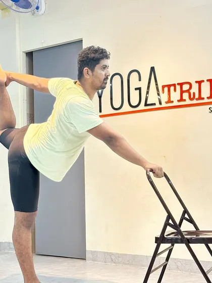 Another angle of the chair-assisted Natarajasana. The chair provides stability, allowing you to focus on opening the shoulder and quadriceps.