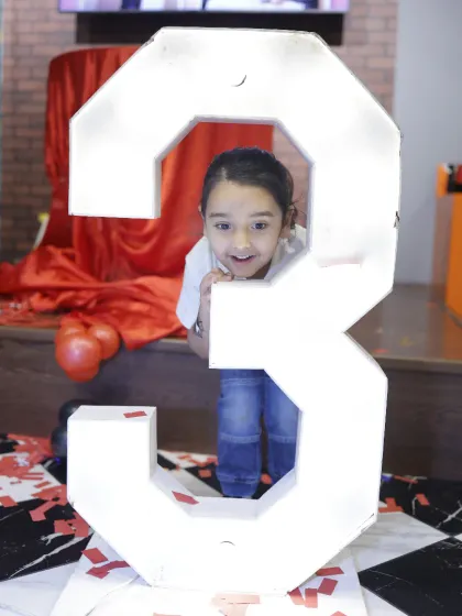 Peeking through the number three. We have large, light-up numbers available to make milestone birthdays feel even more special.