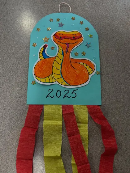 A close-up of a finished Year of the Snake craft, ready to be hung up.