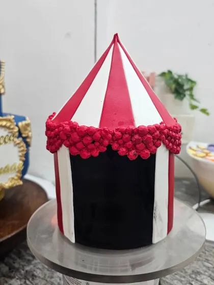 This circus tent cake was part of a larger creation for quadruplets. The cone-shaped top tier is also fully edible cake, a technique I teach in my structural classes.