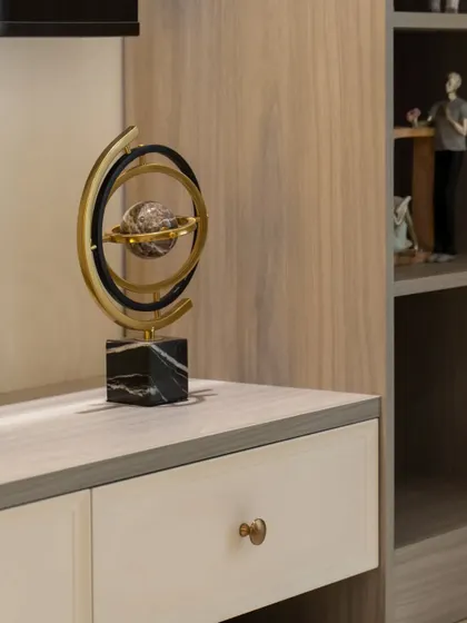 Detail of a sculptural decor piece on the TV console. These small, curated items add personality and a sense of artistry to the minimalist living room.