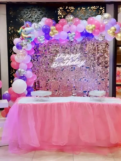 A unicorn-themed first birthday party with a pink sequin wall and a "ONE" table.