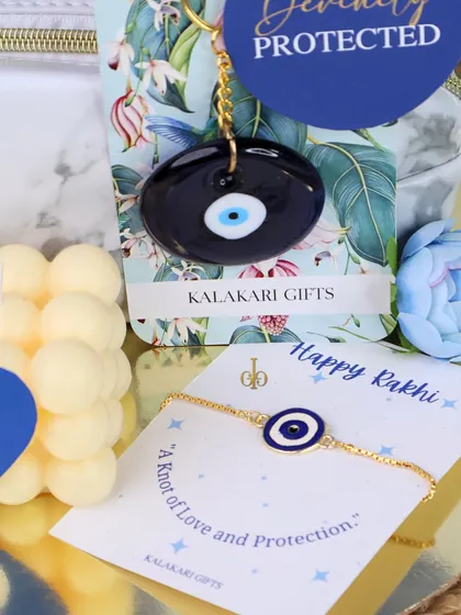 Another angle of the Evil Eye themed Rakhi gift, featuring a delicate evil eye bracelet and a matching keychain, paired with a bubble candle.