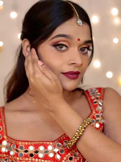 This look combines traditional elements like a bindi and maang tikka with a modern, glamorous makeup style for a festive e-commerce shoot.