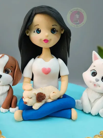 A close-up of the Rupali Ganguly figurine surrounded by her fur babies. This cake was for her birthday, celebrating her love for animals.