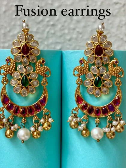 Premium silver gold-plated fusion earrings. This pair features a classic chaandbali design with Kundan work, peacock motifs, and pearl drops, perfect for weddings and festive occasions.