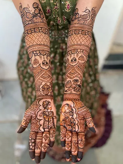 A clear, straight-on view of the beautiful portrait mehandi, showcasing the symmetry and detailed patterns that extend up to the elbows.