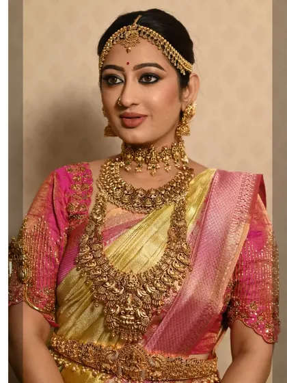 A complete and traditional bridal look. The client is wearing a full set of antique temple jewellery, including a choker, haram, vaddanam, and matha patti, perfect for her muhurtham.