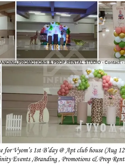 A sweet and simple safari theme for a first birthday at an apartment clubhouse. This setup features a circular backdrop with a balloon garland, giraffe and leopard cutouts, and themed cylinder props for a charming celebration.