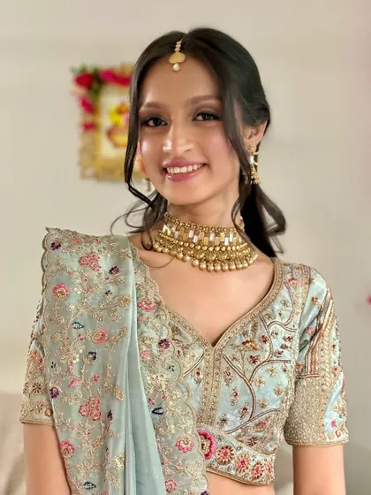 A half-length shot showing the intricate embroidery on her pastel lehenga.