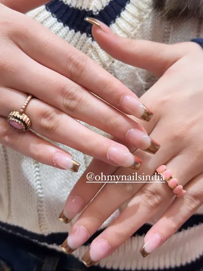 Chic and classy chrome tips. This design elevates the classic French manicure by using a reflective gold chrome polish for the tips on long, square-shaped nails.