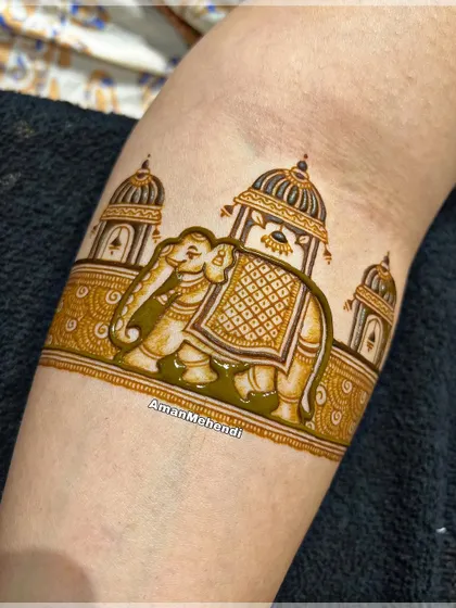 A close-up of a royal elephant motif on the arm. The intricate details on the elephant's saddle and the surrounding palace architecture showcase fine linework.