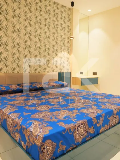 Another bedroom in the Palakkad home, featuring a unique patterned wallpaper and custom-built bedside units that blend style with practicality.