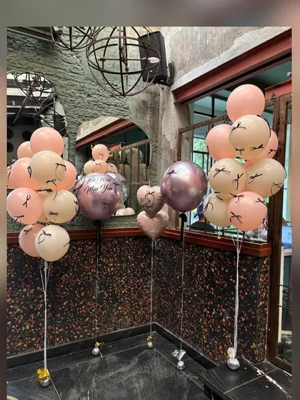 Custom balloon bunches for a stylish bridal shower. These arrangements feature a mix of pastel, metallic, and custom-printed balloons with eyelash details, adding a fun and fashionable touch to the party decor.