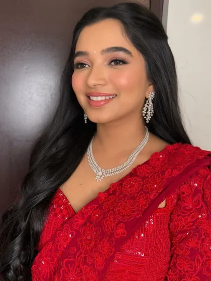 A smiling shot that shows off the dewy skin and polished makeup, perfect for a happy Sangeet celebration.