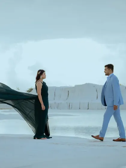 A dynamic "first look" style shot, with the groom walking towards the bride. The movement in her gown adds a sense of anticipation and romance to this pre-wedding photo.