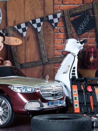 This older baby is ready to get his hands dirty in the garage. His happy expression shows how much fun these themed shoots can be for toddlers too.