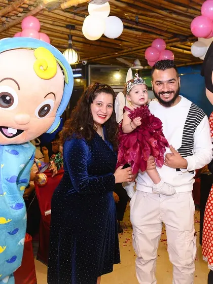 Fun with mascots! The birthday girl and her family pose with Cocomelon and Minnie Mouse characters.