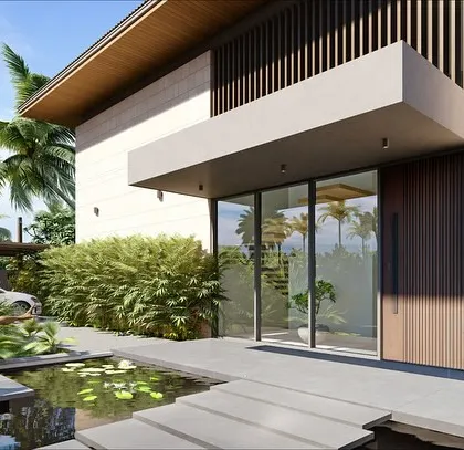 The entrance to a Goa villa, featuring a serene water body with lily pads and floating steps. The design uses a combination of stone cladding and wooden louvers to create a welcoming and texturally rich facade.