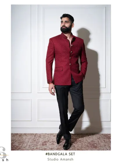 A full-length shot of the crimson Bandhgala, showing how it pairs with classic black trousers for a sharp, formal look.