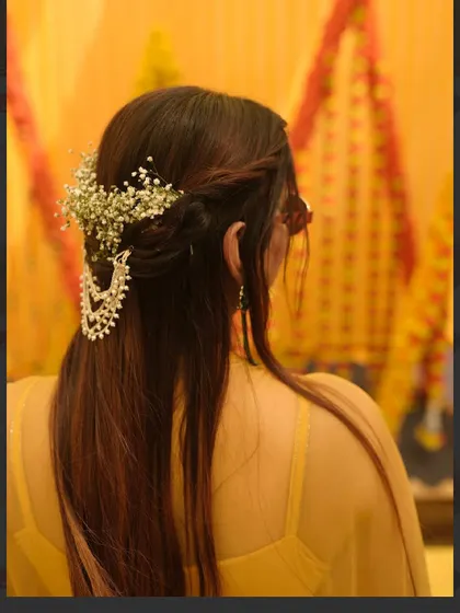A close-up of the Haldi hairstyle with baby's breath and a silver accessory. It’s a beautiful combination of modern and traditional elements.