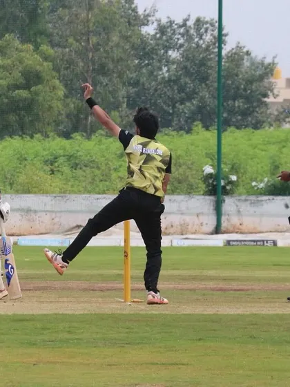 A spinner in action during a youth match, demonstrating good bowling form.