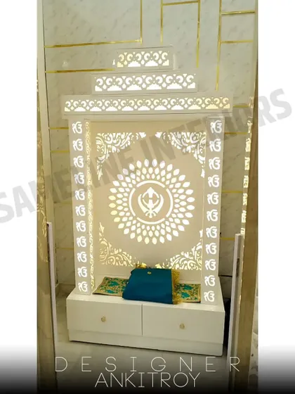 Another example of a custom mandir with 'Ek Onkar' jali work, this one featuring drawers for storage.