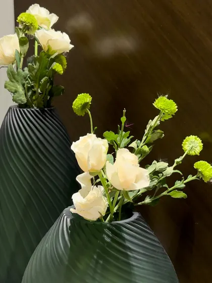 Minimalist and modern decor, featuring simple white and green flowers in textured matte green vases.