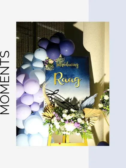 The welcome sign for 'Raag's' naming ceremony, decorated with a balloon garland and floral arrangement.
