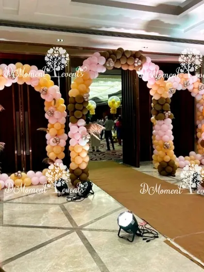A double balloon arch entrance in a chic brown, peach, and pink color scheme, perfect for a modern and stylish Boho-themed celebration.