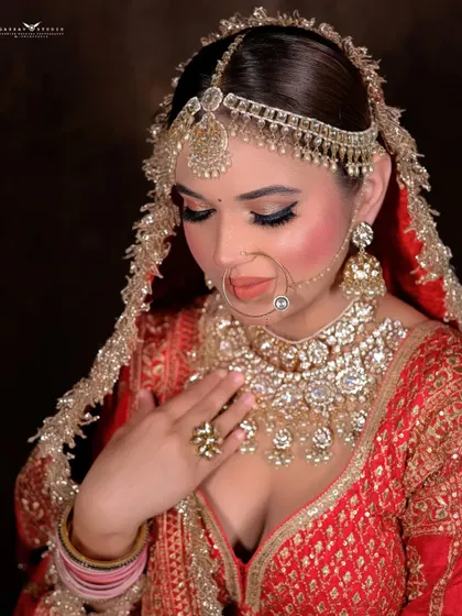 A beautiful close-up focusing on the bride's jewellery. Her hand rests gently on her chest, drawing attention to the magnificent layered necklace.
