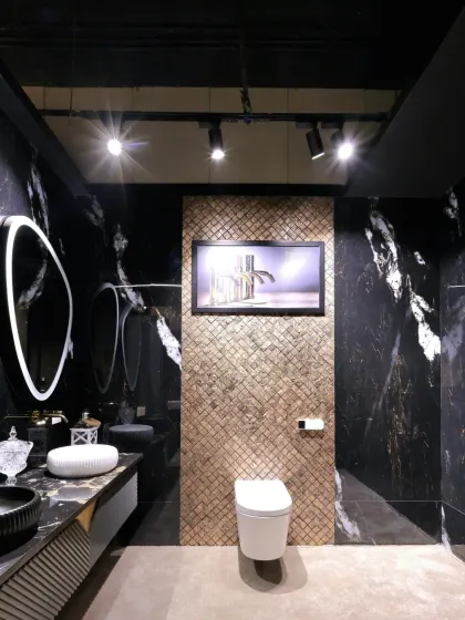 This angle showcases the contrast between the dramatic black marble and the intricate gold-textured accent wall.