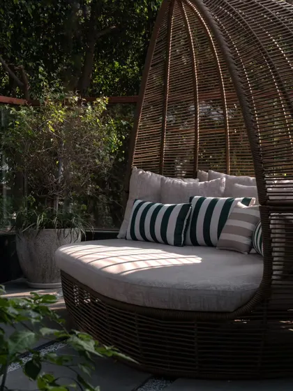 A close-up of the comfortable daybed, where striped cushions add a touch of classic, relaxed style.