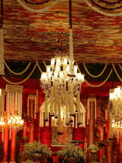 The ceiling was a canvas of its own, with a traditional printed fabric adorned with dozens of floral-draped chandeliers, creating a sky of light and opulence.