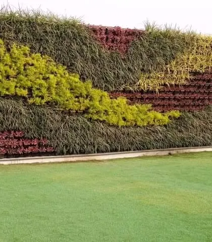 The vibrant chartreuse and deep green grasses in this section of the wall create a beautiful, flowing design. Our expertise in plant selection allows us to paint with nature, crafting durable and artistic outdoor greening solutions.