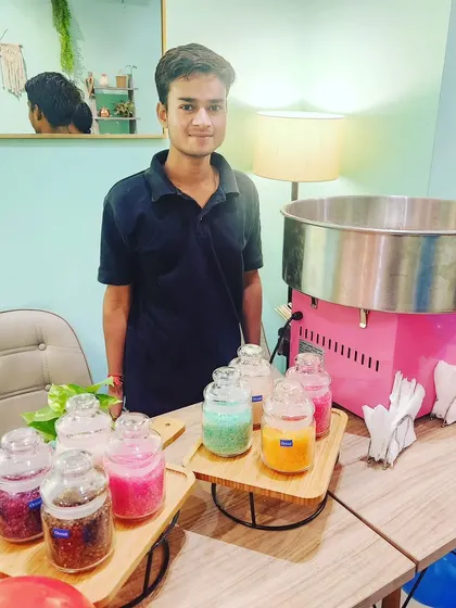 Our friendly staff member is ready to spin up some delicious candy floss for the party guests.