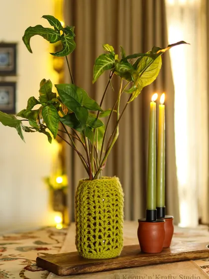The green vase cover, catching the warm glow of candlelight.