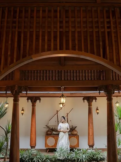 A wide, architectural shot of the bride standing in a stunning traditional courtyard, showcasing the beauty of the venue.